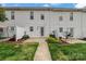 Townhome backyard featuring a patio area, white fence, and well-maintained grass at 128 Locomotive Ln, Mooresville, NC 28115