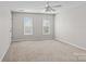 Neutral bedroom featuring two windows, beige carpet and a ceiling fan at 128 Locomotive Ln, Mooresville, NC 28115