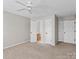 Bedroom with neutral walls and beige carpeting. Three doors with black hardware at 128 Locomotive Ln, Mooresville, NC 28115