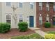A close-up of townhome number 108 with neutral siding, blue front door, and manicured landscaping at 128 Locomotive Ln, Mooresville, NC 28115