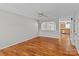 Bright living room featuring hardwood floors, ceiling fan, and view into the kitchen at 128 Locomotive Ln, Mooresville, NC 28115