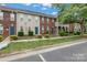 Charming townhomes featuring a mix of brick and siding exteriors, blue doors, and well-maintained landscaping at 128 Locomotive Ln, Mooresville, NC 28115