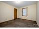 Cozy bedroom featuring neutral walls, carpet, a window with blinds, and a wood-trimmed door at 2078 Valley View Ln, Lincolnton, NC 28092