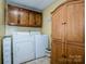 Practical laundry room with washer, dryer, ample cabinet space, and neutral color scheme at 2078 Valley View Ln, Lincolnton, NC 28092