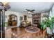 Cozy living room featuring hardwood floors, brick fireplace, ceiling fan, and an open archway to the kitchen at 2078 Valley View Ln, Lincolnton, NC 28092