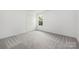 This bedroom has neutral carpet, white walls, a window, and closet space, providing a versatile living area at 2313 Stallings Rd, Harrisburg, NC 28075