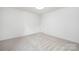 A simplistic bedroom showcases neutral carpet, white walls, ceiling light, and a door at 2313 Stallings Rd, Harrisburg, NC 28075