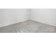 Bright bedroom featuring neutral carpet, white walls, and a door that enhance the living space at 2313 Stallings Rd, Harrisburg, NC 28075