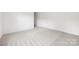 A serene bedroom featuring neutral carpet, white walls, and a door at 2313 Stallings Rd, Harrisburg, NC 28075
