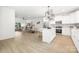 Open concept living room and kitchen with island, stainless steel appliances, and modern lighting at 2313 Stallings Rd, Harrisburg, NC 28075