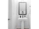 A modern powder room with a pedestal sink, stylish fixtures, and decorative mirror at 2313 Stallings Rd, Harrisburg, NC 28075