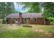 Brick home featuring a cozy patio, well-maintained yard, and mature landscaping at 2418 Live Oak Ct, Gastonia, NC 28056