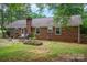 The backyard features a brick house with patio with barbeque, fireplace and furniture at 2418 Live Oak Ct, Gastonia, NC 28056