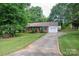Inviting home exterior with a long driveway, green lawn, and mature trees providing shade and character at 2418 Live Oak Ct, Gastonia, NC 28056