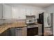 Well-equipped kitchen featuring stainless appliances, granite counters, tile backsplash, and ample cabinet space at 2418 Live Oak Ct, Gastonia, NC 28056