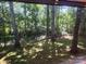 View of the wooded backyard from inside the home's large window, creating a peaceful and private setting at 2461 Ridgecrest Dr, Stanley, NC 28164