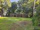 Charming one-story home with green shutters surrounded by mature trees and a well-maintained lawn at 2461 Ridgecrest Dr, Stanley, NC 28164