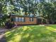 Charming one-story home with green shutters surrounded by mature trees and a well-maintained lawn at 2461 Ridgecrest Dr, Stanley, NC 28164