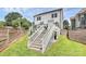 Backyard with stairs leading to a patio featuring a landscaped garden and white railing at 2600 Palm Ave, Charlotte, NC 28205