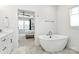 Bright bathroom featuring a modern tub, marble floor, and a view into an adjacent bedroom at 2600 Palm Ave, Charlotte, NC 28205