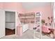Pink bedroom featuring a high bed, white dresser, desk, and neutral carpet flooring at 2600 Palm Ave, Charlotte, NC 28205