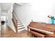 Inviting entryway featuring a staircase, hardwood floors, and a vintage piano at 2600 Palm Ave, Charlotte, NC 28205