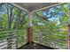 Charming porch features brick columns and a wrought-iron railing with wooded views at 2625 E 5Th St # F, Charlotte, NC 28204