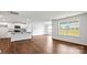 Open concept living area featuring hardwood floors, a modern kitchen, white walls, and large windows for natural light at 2656 Goose Fair Rd # 126, Maiden, NC 28650