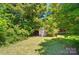 Backyard featuring a charming storage shed nestled among trees at 2722 Catawba Church Rd, Rock Hill, SC 29730