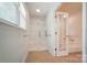 Bright white bathroom with a shower and view of a tub through glass french doors at 2722 Catawba Church Rd, Rock Hill, SC 29730