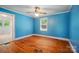 Bright blue bedroom with hardwood floors, a ceiling fan, and a view to an attached room at 2722 Catawba Church Rd, Rock Hill, SC 29730