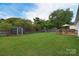 Spacious backyard featuring a storage shed, playset, a deck with an umbrella and grill, and plenty of green space at 2836 Rosemeade Dr, Monroe, NC 28110