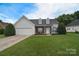 Charming single-Gathering home featuring a manicured lawn, attached garage, and inviting front porch with dormer windows at 2836 Rosemeade Dr, Monroe, NC 28110