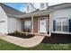 Close up of a home's front porch, showcasing a brick facade, seating, and an inviting entryway at 2836 Rosemeade Dr, Monroe, NC 28110