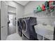 Convenient laundry room with modern washer and dryer, a utility sink, and storage shelves at 3255 Split Rail Ln, Lancaster, SC 29720
