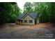 Charming single-story home with light green siding, black shutters, and attached garage nestled among lush trees at 3452 Hands Mill Hwy, York, SC 29745