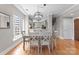 Modern dining area with stylish chandelier and view into kitchen, complemented by hardwood floors and neutral tones at 400 N Church St # 422, Charlotte, NC 28202