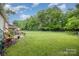 A spacious, fenced backyard featuring mature trees and a patio with a table and chairs at 401 Yadkin St, Granite Quarry, NC 28072