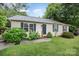 Well-maintained single-story home with blue shutters, a lush green lawn, and inviting front yard landscaping at 401 Yadkin St, Granite Quarry, NC 28072