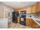 This spacious kitchen offers black appliances, tile backsplash, light countertops and wood cabinets at 401 Yadkin St, Granite Quarry, NC 28072