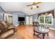 Inviting living room featuring hardwood floors, vaulted ceilings, a ceiling fan, and cozy decor for comfortable living at 401 Yadkin St, Granite Quarry, NC 28072