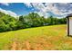 Spacious backyard featuring a lush lawn and scenic tree line for outdoor enjoyment at 415 Kickapoo Ave, Gastonia, NC 28056