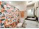 Bathroom with a peach-themed shower curtain, white vanity, and neutral finishes at 415 Kickapoo Ave, Gastonia, NC 28056