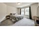 Comfortable bedroom with a floral patterned bed, side table and large windows at 415 Kickapoo Ave, Gastonia, NC 28056