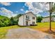 Exterior of a modern home with white siding, black trim, and a gravel driveway, set against a partly cloudy sky at 415 Kickapoo Ave, Gastonia, NC 28056