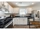 Bright kitchen with stainless steel appliances, white cabinets, and wood-look floors at 415 Kickapoo Ave, Gastonia, NC 28056