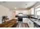 White kitchen featuring white cabinets, black countertops, stainless steel appliances, and wood floors at 415 Kickapoo Ave, Gastonia, NC 28056