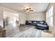 Open-concept living room with a gray sofa, ceiling fan, and hardwood floors at 415 Kickapoo Ave, Gastonia, NC 28056