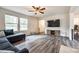 Comfortable living room with a TV, ceiling fan, neutral walls, and wood-look floors at 415 Kickapoo Ave, Gastonia, NC 28056