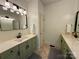 Bright bathroom with dual sinks, green cabinetry and updated fixtures at 4230 Berry Hill Ct, Concord, NC 28025